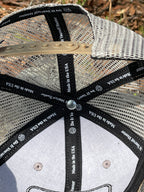 Inside view of a Do It Yourself Hunter camo cap with brown mesh backing and adjustable strap, showcasing the cap's interior and design.